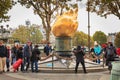 Tourists gather in front of the flame of freedom