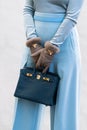 Paris, France - October, 1: woman wearing navy blue ostrich leather Birkin handbag from Hermes, street style outfit.