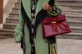 Paris, France - October, 1: woman wearing vintage Kelly 32 bag from Hermes in burgundy calf box leather, street style