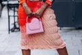 Paris, France - October, 3, 2021: woman wears clutch pink bag