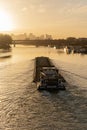 Paris, France - 01 30 2022: Quays of the Seine. View of the freight of a barge sailing along the Seine and The Defense district at