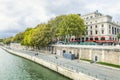 Paris, France, 09/10/2019: Seine embankment with people walking and a cafe. Beautiful city landscape Royalty Free Stock Photo