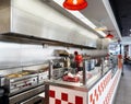 Young worker preparing burgers french fries at inside Five Guys