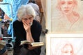 PARIS / FRANCE - September 24, 2011: Artist read a book in Montmartre, the legendary bohemian artist district of Paris. Next to th