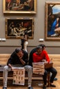 Couple tourists reading guide brochure in Louvre museum