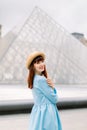 PARIS, FRANCE - September 17, 2019: Pretty elegant young red haired woman in blue dress, posing to camera while standing