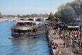Banks of Seine with huge number of tourists and large floating restaurant