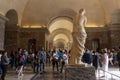 Tourists admiring the Venus de Milo exhibited at the Louvre Museum