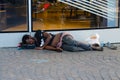 Homeless dark-skinned man is sleeping on street of Paris, France Royalty Free Stock Photo