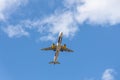 Paris, France - 07 07 2023: White and blue plane with chassis is landing on the sky with clouds background Royalty Free Stock Photo