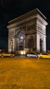 PARIS - March 10, 2023: The Arch of Triumph of the Star The Arc de Triomphe de l\'Etoile and traffic lights at night. Paris Royalty Free Stock Photo