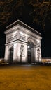 PARIS - March 10, 2023: The Arch of Triumph of the Star The Arc de Triomphe de l\'Etoile and traffic lights at night. Paris Royalty Free Stock Photo