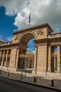 French flag over stone arch and golden iron gate richly decorated in sunny day at Paris. Royalty Free Stock Photo