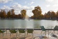 Tuileries garden with green chairs and fountain, sunny autumn in Paris