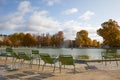 Tuileries garden with green metal chairs and fountain in a sunny autumn day in Paris