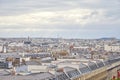 Paris rooftops view and city skyline in a cloudy day with sun in France