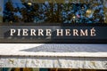 Paris - September 10, 2019 : The Pierre Herme pastry store entrance sign on Champs-Elysees avenue