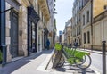 Green electric bicycles with baskets for public rent stand in row on street of Paris awaiting cyclists