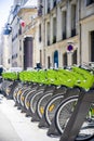 Green electric bicycles with baskets for public rental await cycling tourists on the streets of old Paris Royalty Free Stock Photo