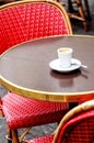 Parisian cafe terrace with red chairs and an espresso Royalty Free Stock Photo