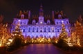 Parisian City Hall decorated with Christmas trees for winter holidays at night. Winter travel and tourist attractions in