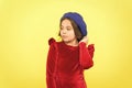 parisian kid in french beret hat and elegant red dress on yellow background, retro fashion