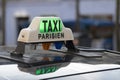 Parisian Taxi sign and car waiting for customer in the Paris streets