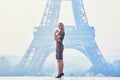 Parisian woman near the Eiffel tower at morning Royalty Free Stock Photo