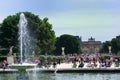 Parisians relaxing at Tuleries with fountain and lourve in background