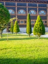 Park area. Well-groomed lawn of the park. Wooden architecture and topiary bushes