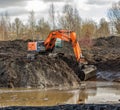 Powerful excavator HITACHI digs a pond in the park