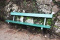 Park bench in green against a natural stone wall Royalty Free Stock Photo