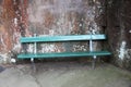 Park bench in green against a natural stone wall Royalty Free Stock Photo
