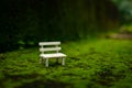 A park bench on green surface with a nice blurry bokeh effect. miniature photography art, light bokeh, photography, background, Royalty Free Stock Photo