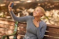 Park bench, phone selfie and black woman in nature outdoors taking picture. Happy, smile and girl from South Africa with