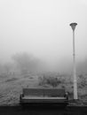 Park bench and pole in the freezing fog Royalty Free Stock Photo