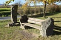 park bench from volcano stone and wethered wood next to a stone with crosses at the way
