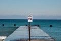 `Park Closes 11 PM` sign at wooden pier of Lake Michigan