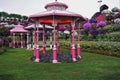 Park design. Openwork awnings on pink pillars stand on the lawn.