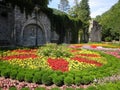 Park with flowers at summer, ornamental flowergarden next to ancient building