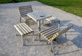 Park furniture chess table and chairs for four persons made of light metal and wooden beams with backrest on bright glade area gra