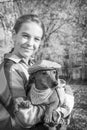 In the park, a girl holds a dachshund dog in her arms. Black and white photo Royalty Free Stock Photo