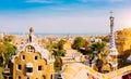 Park Guell Barcelona, Catalonia, Spain. Porter lodge colorful tower and details of ceramic bench. Warm sunlight on