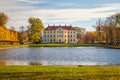 Park with a lordly castle behind a pond in autumn Royalty Free Stock Photo