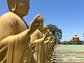 Buddhist temple in the city of Foz do Iguacu. Open patio in front of the temple with trees and garden. Profiled golden status.