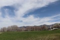 A park near Salt Lake city Utah with leafless trees, a tennis court, and home in the background and the wasatch mountains