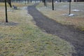 Park path through an English park with old tree-covered trunks. trowel gray path for bicycles and pedestrians in winter. snow, ici Royalty Free Stock Photo