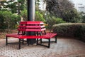 Park red bench located around the column