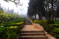 Park with stone brick path and stairs lined with trimmed hedges on a foggy day in Phu Yen, Vietnam