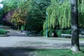 Park with trees and benches along riverbank Royalty Free Stock Photo